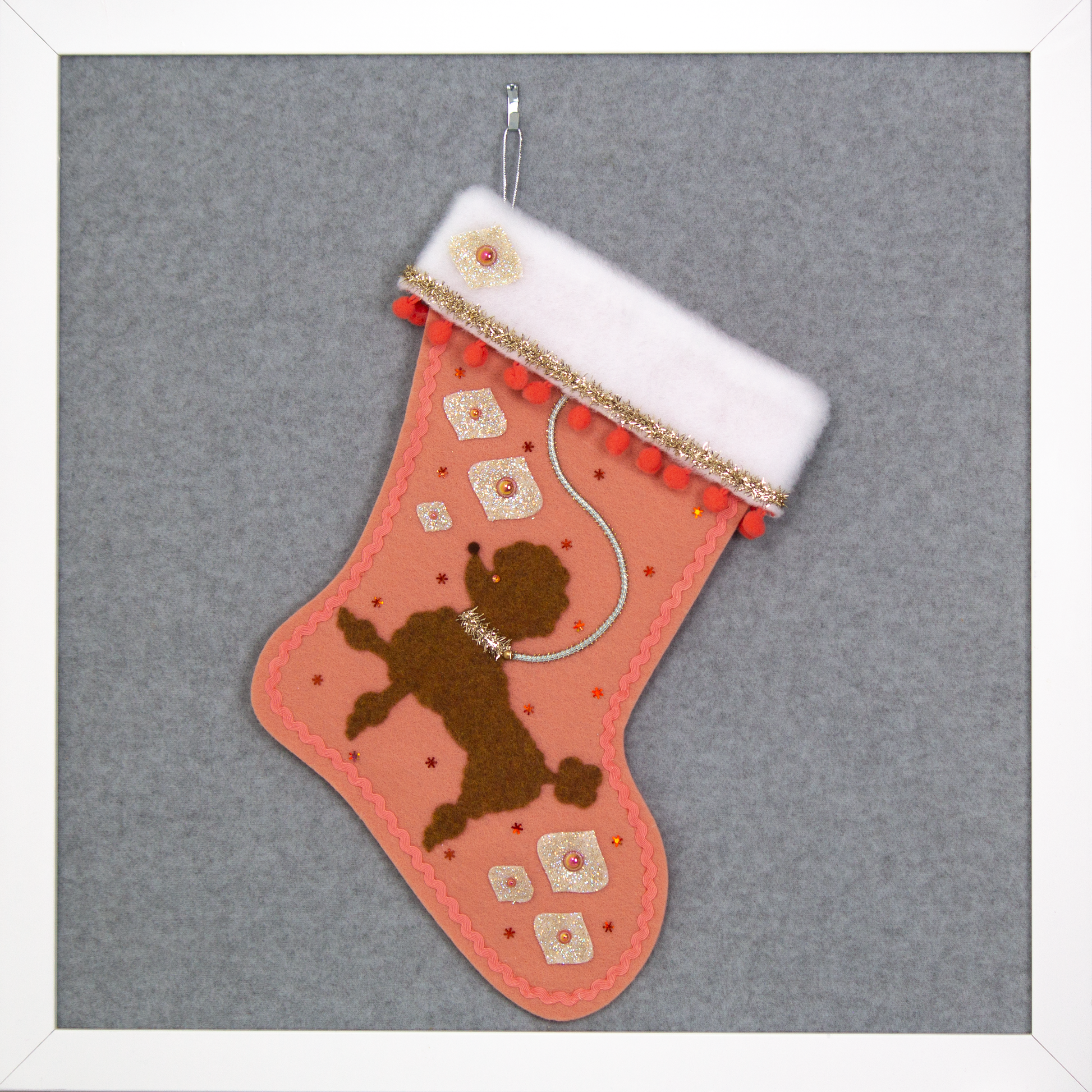 Decorative Christmas stocking with a copper poodle on coral felt with gold accents.