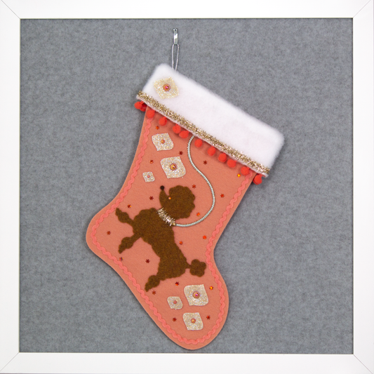Decorative Christmas stocking with a copper poodle on coral felt with gold accents.