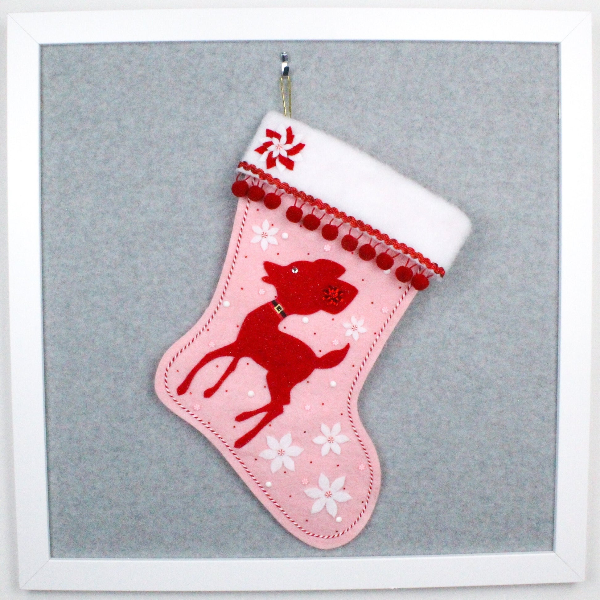 Red deer on light pink felt OOAK handmade Christmas stocking with white poinsettia flowers, red & white striped decoration and red pom poms.