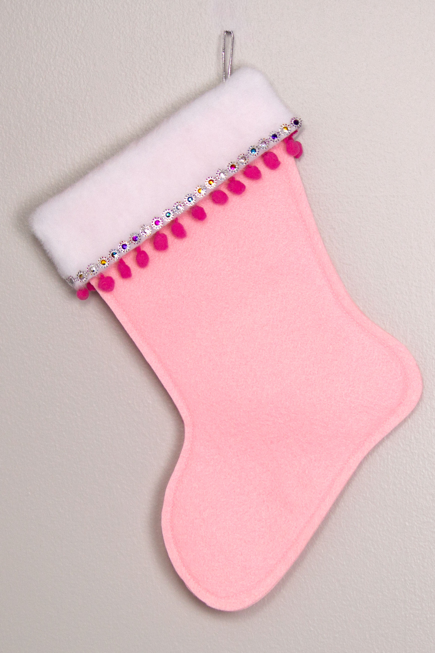 Light pink felt handmade Christmas stocking with pom poms and decorated in hot pink, multicolors & silver. (back of marquise Santa stocking)