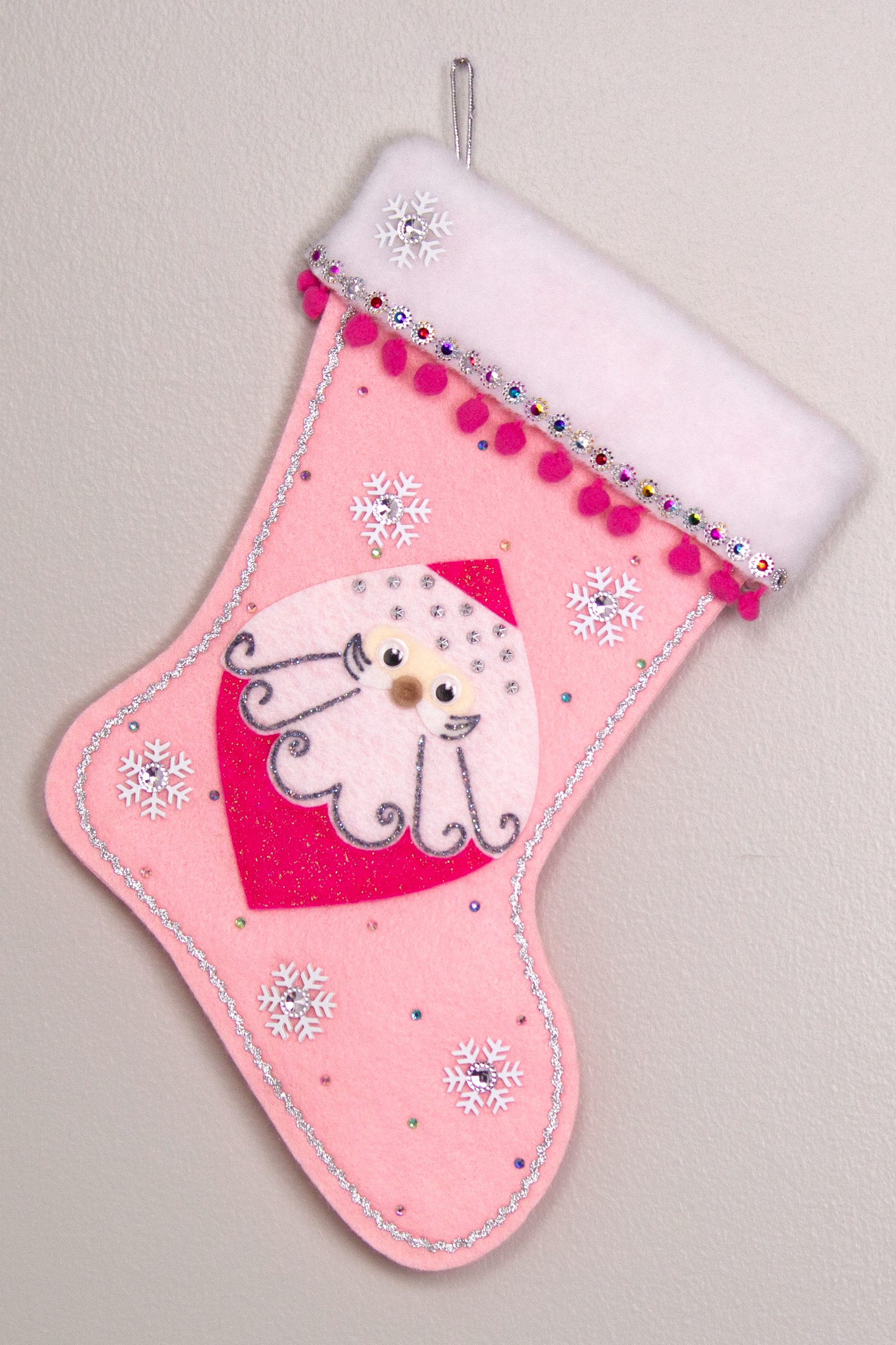 Marquise shaped Santa head (Holt Howard inspired) in hot pink glitter on a light pink felt handmade Christmas stocking with snowflake buttons, pom poms and decorated in hot pink, white, multicolors & silver. (front of stocking)
