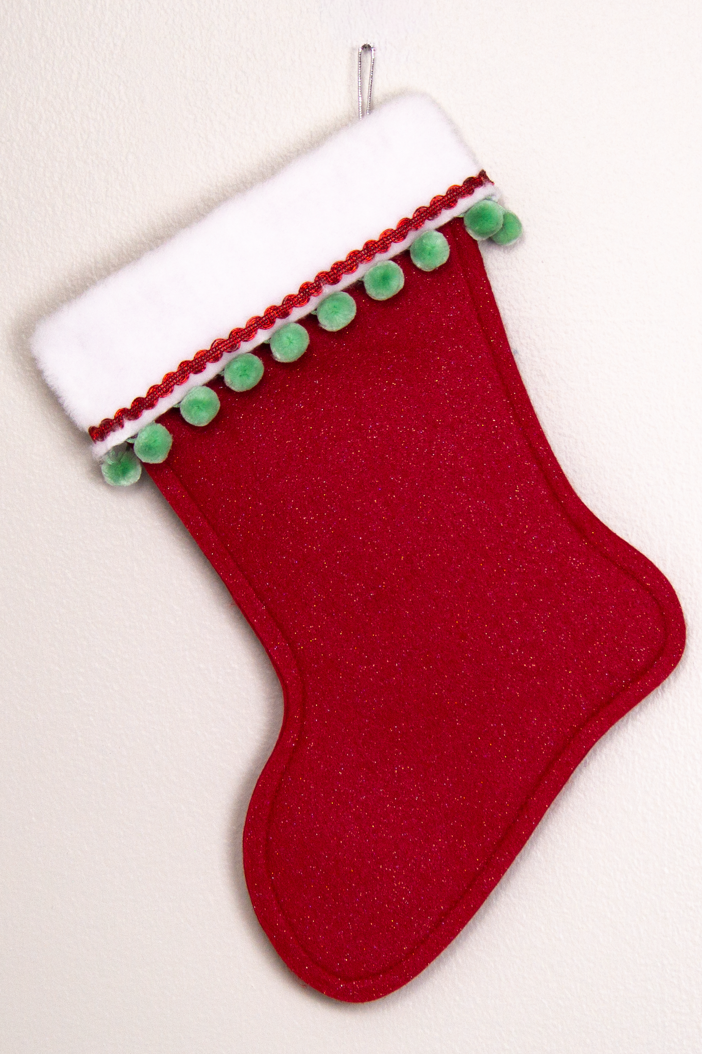 Red glitter felt handmade Christmas stocking with pom poms and decorated in red, mint green & silver. (back of marquise shaped Santa stocking)