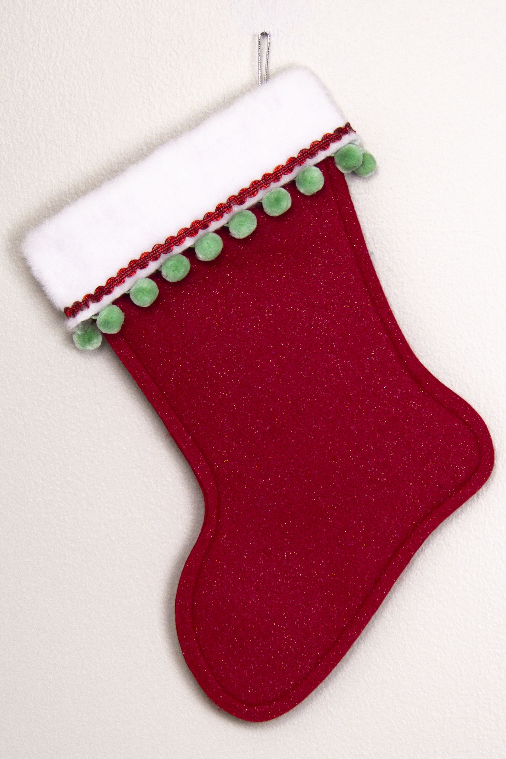 Red glitter felt handmade Christmas stocking with pom poms and decorated in red, mint green & silver. (back of marquise shaped Santa stocking)