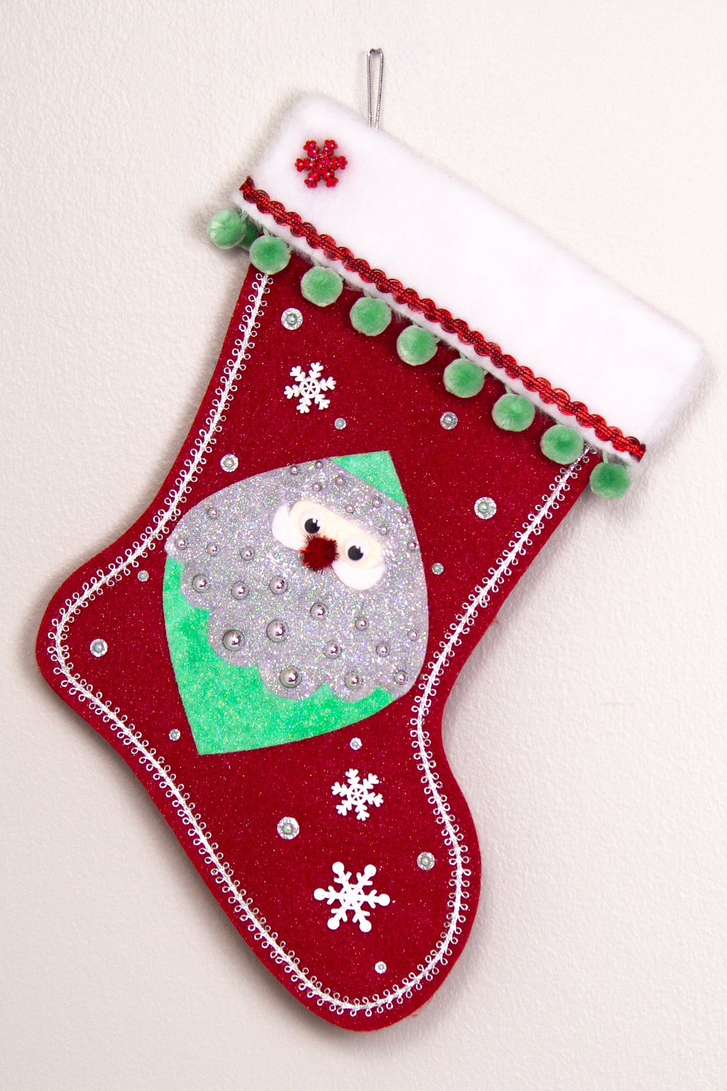 Marquise shaped Santa head (Holt Howard inspired) in silver and mint green glitter on a red glitter felt handmade Christmas stocking with wood snowflakes, pom poms and decorated in red, mint green & silver. (front of stocking)