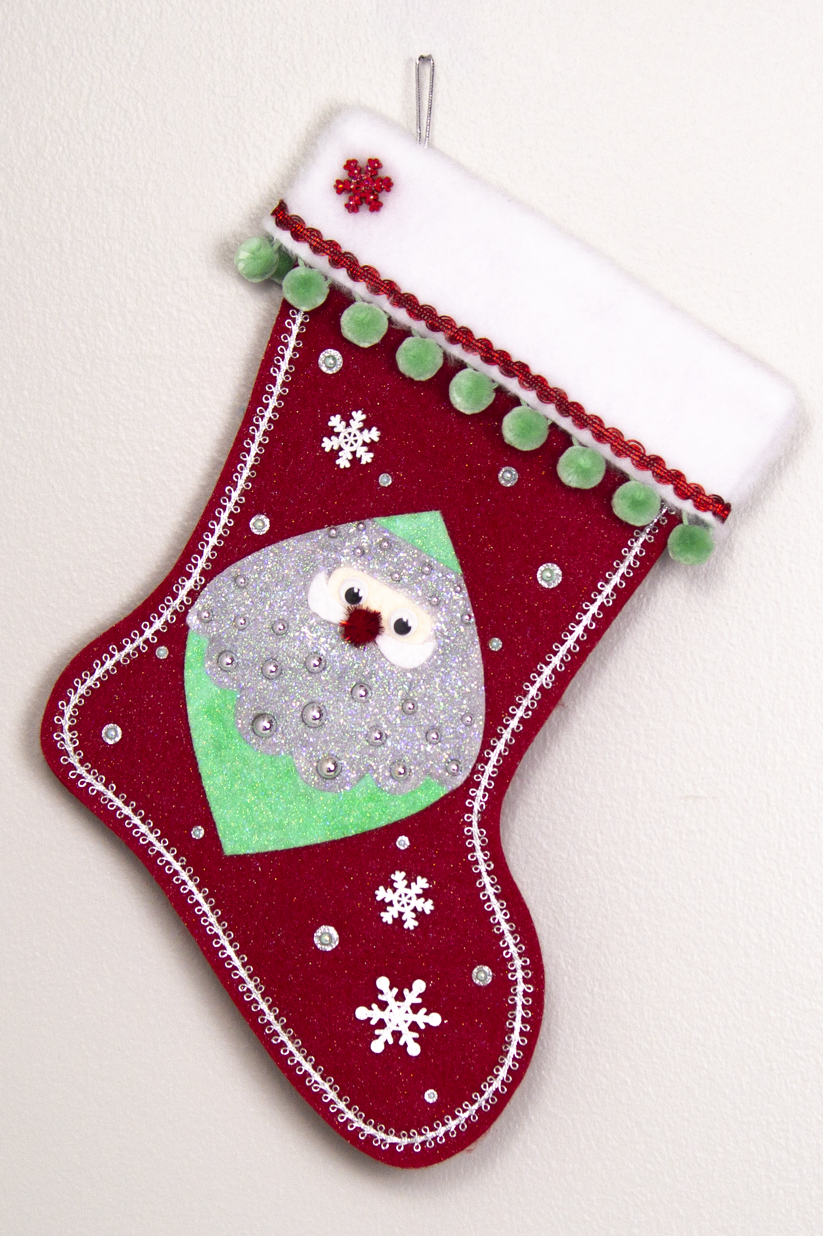Marquise shaped Santa head (Holt Howard inspired) in silver and mint green glitter on a red glitter felt handmade Christmas stocking with wood snowflakes, pom poms and decorated in red, mint green & silver. (front of stocking)