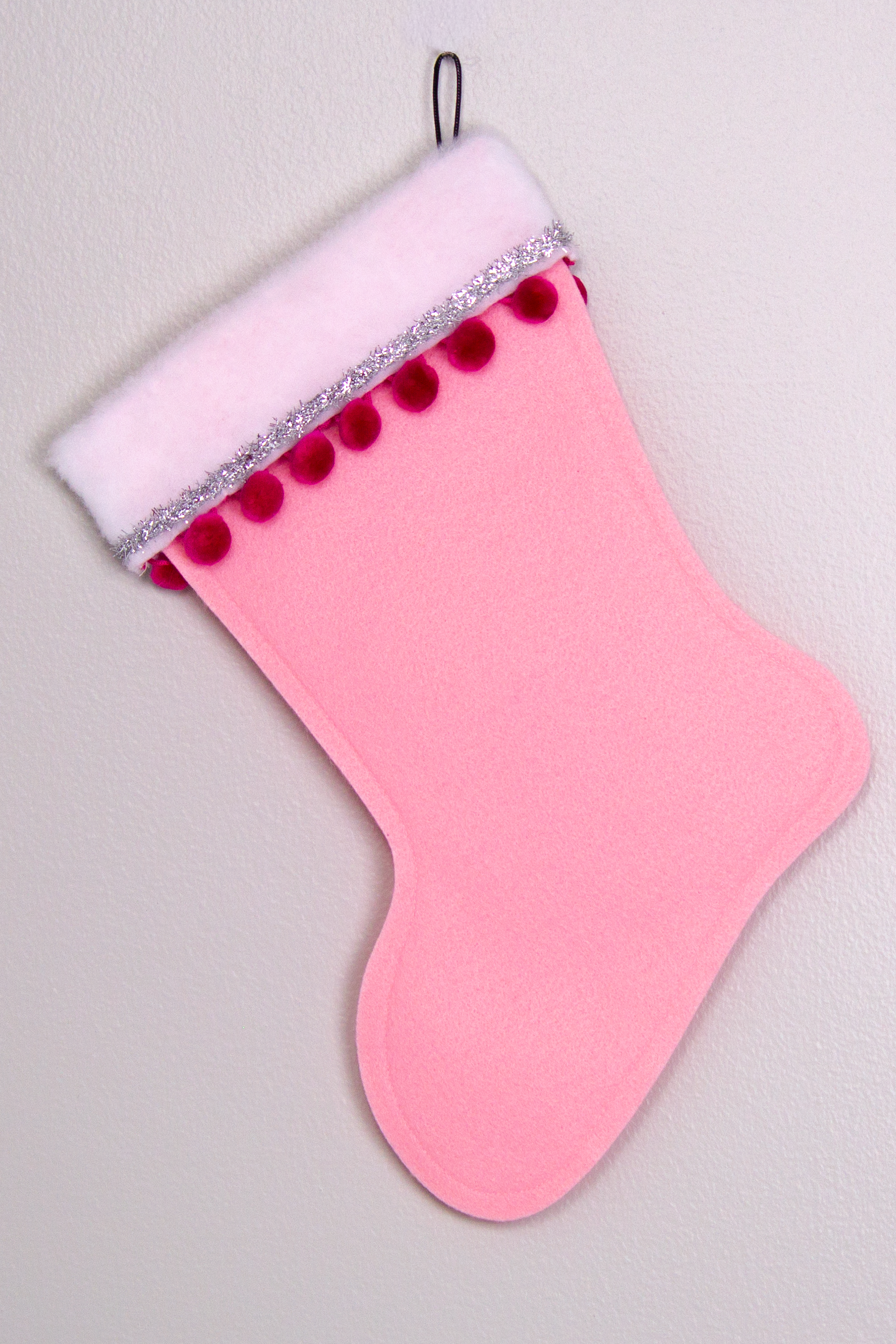 Light pink felt handmade Christmas stocking with pom poms, tinsel ribbon and decorated in hot pink & silver. (back of Santa stocking)