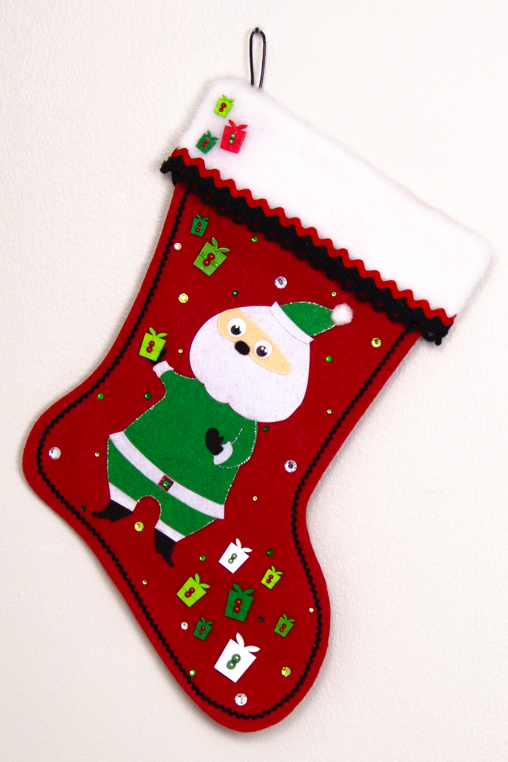 Retro Santa in green suit on a holiday red felt handmade Christmas stocking with boxes and decorated in black, white, greens and silver. (front of stocking)