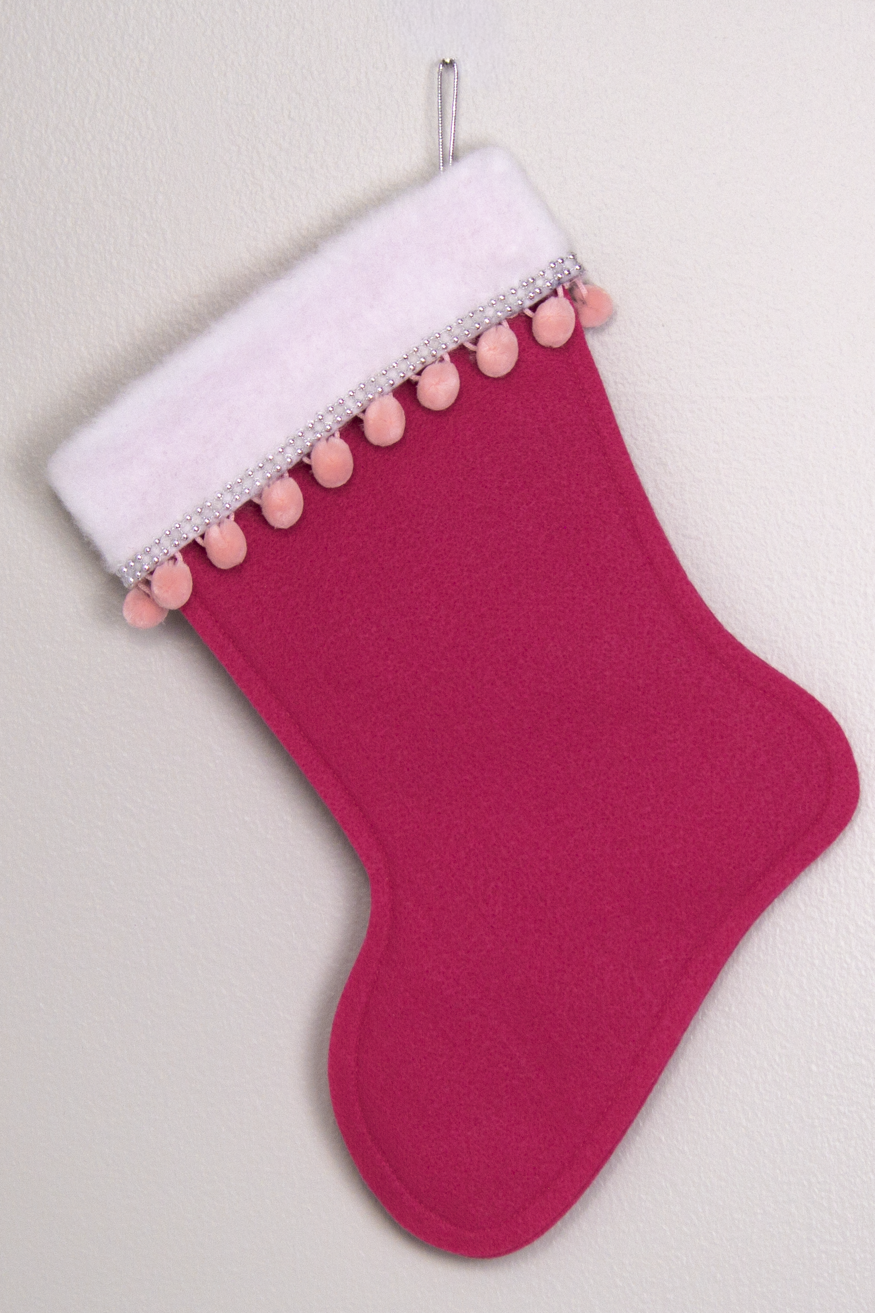 Bright pink felt handmade Christmas stocking with pom poms and decoration in pink & silver. (back of triangle Santa stocking)