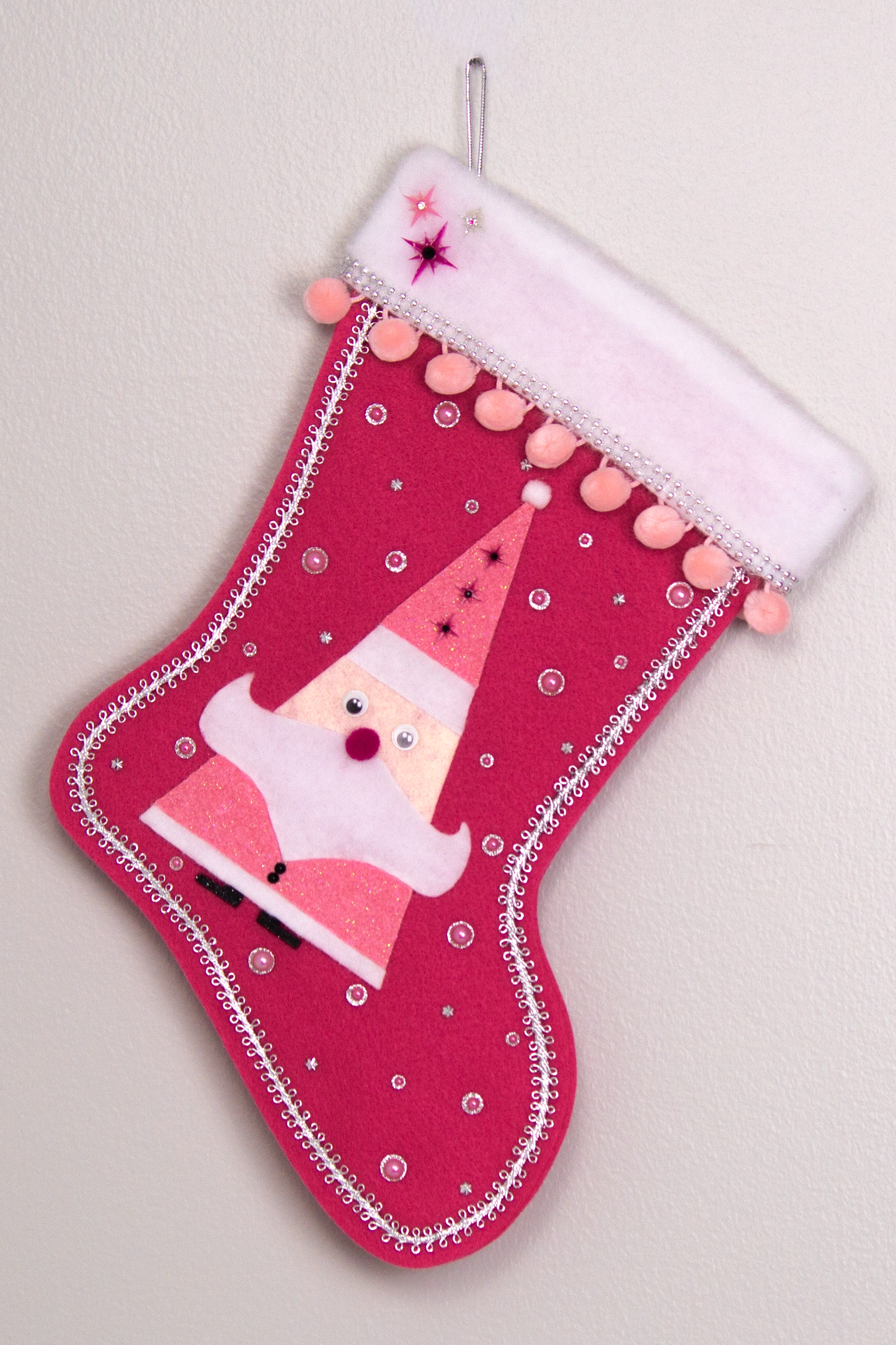 Triangular Santa (Holt Howard for Libbey inspired) in chunky pink glitter suit on bright pink felt handmade Christmas stocking with starbursts, pom poms and decoration in various pinks, black, white & silver. (front of stocking)