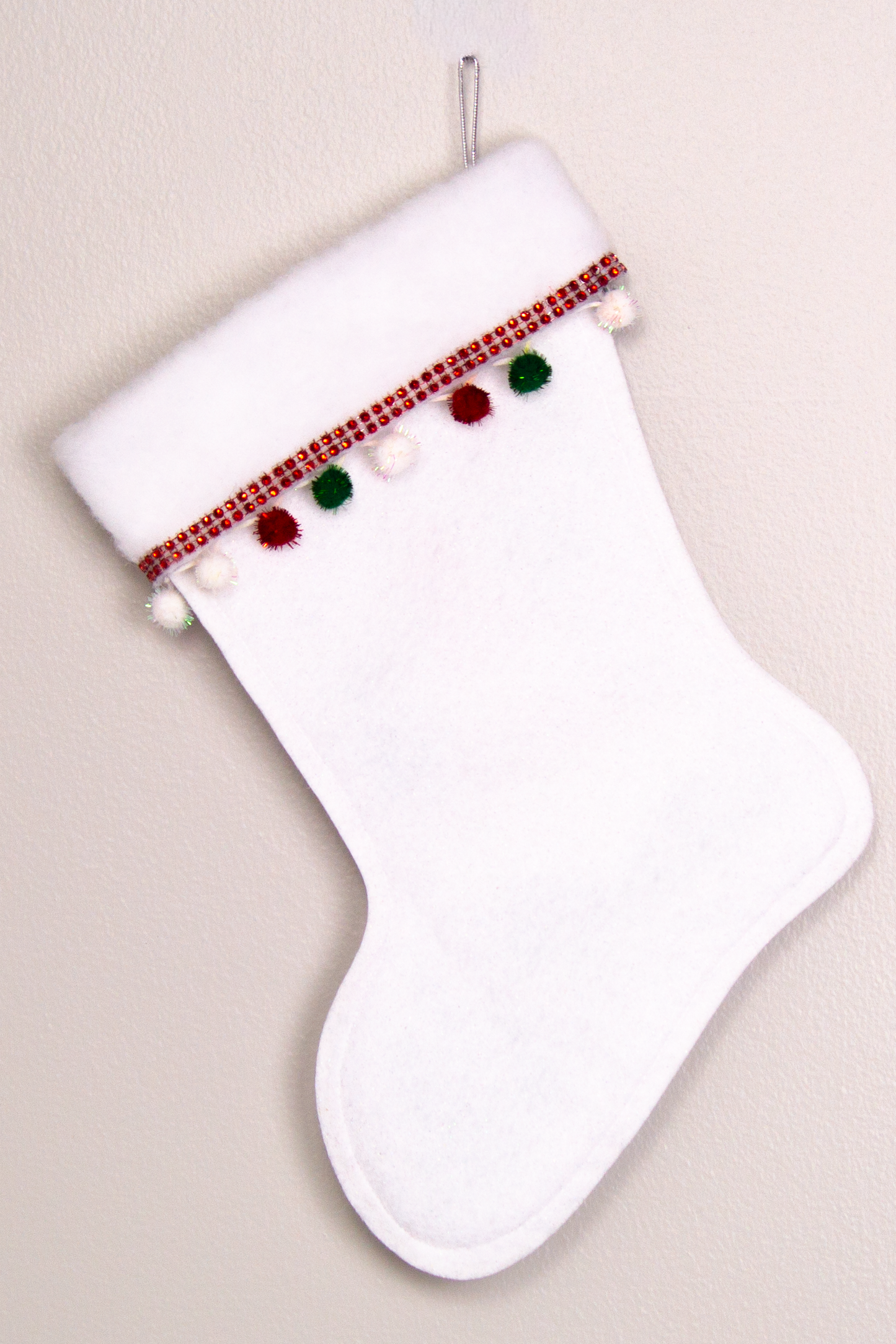White glitter felt handmade Christmas stocking with sparkly pom poms and decoration in red, green, white & silver. (back of triangle Santa stocking)