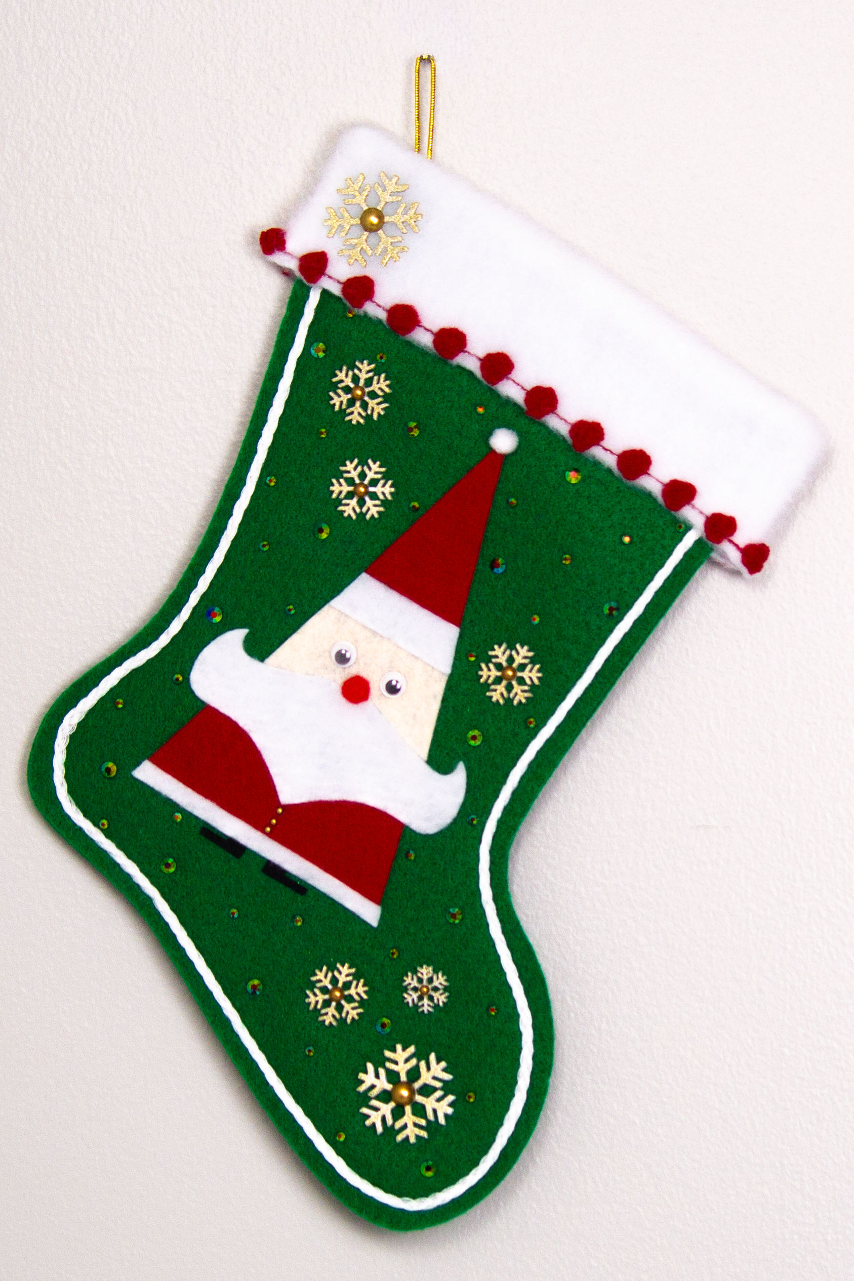 Triangular Santa (Holt Howard for Libbey inspired) in red suit on holiday green felt handmade Christmas stocking with glittered snowflake buttons, poms and decoration in white, red, holographic green & gold. (front of stocking)