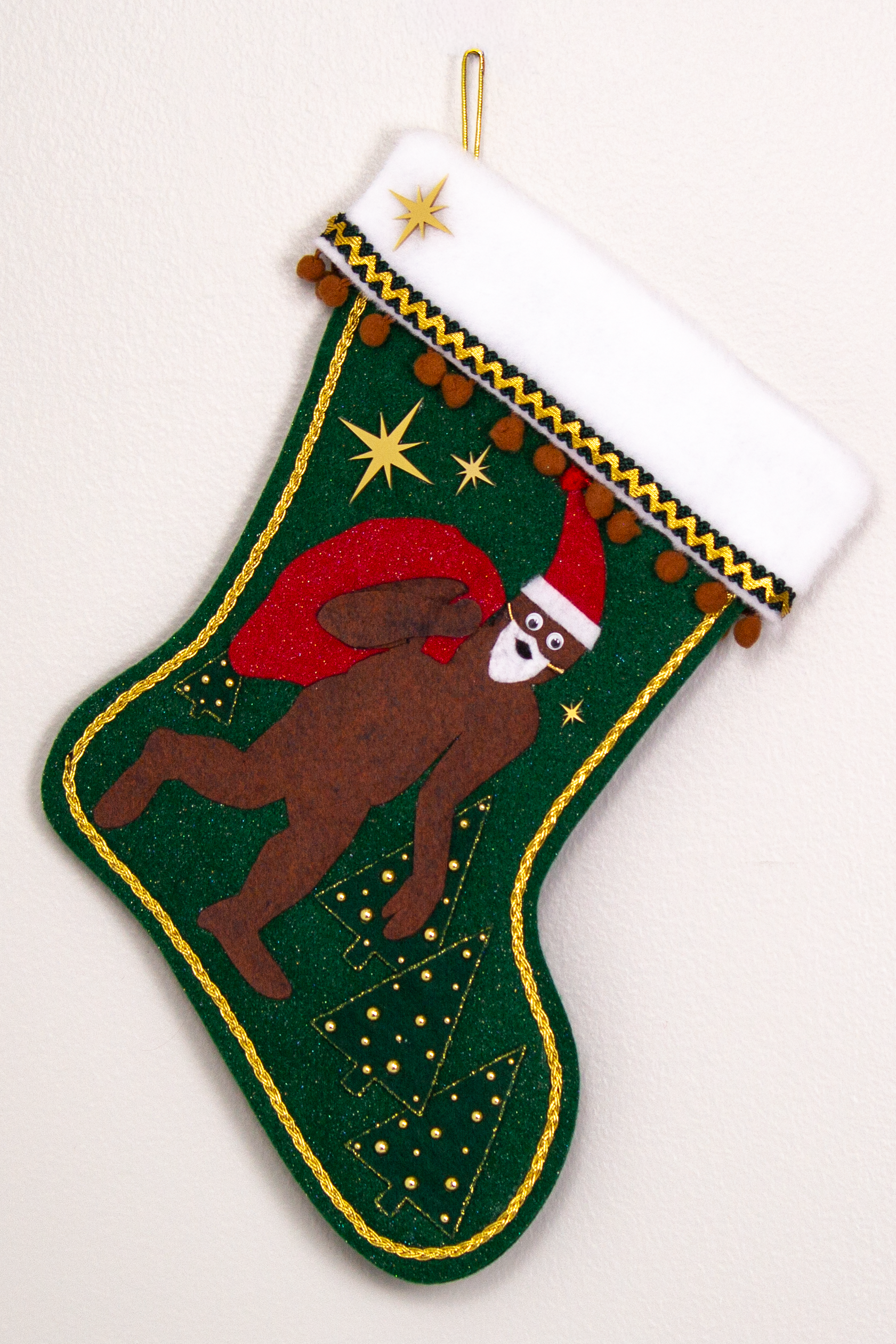 Felt Sasquatch Santa, red glitter bag/hat on dark green glitter felt handmade Christmas stocking with pom poms, trees, acrylic starbursts and decorated in brown, red & gold. (front of stocking)
