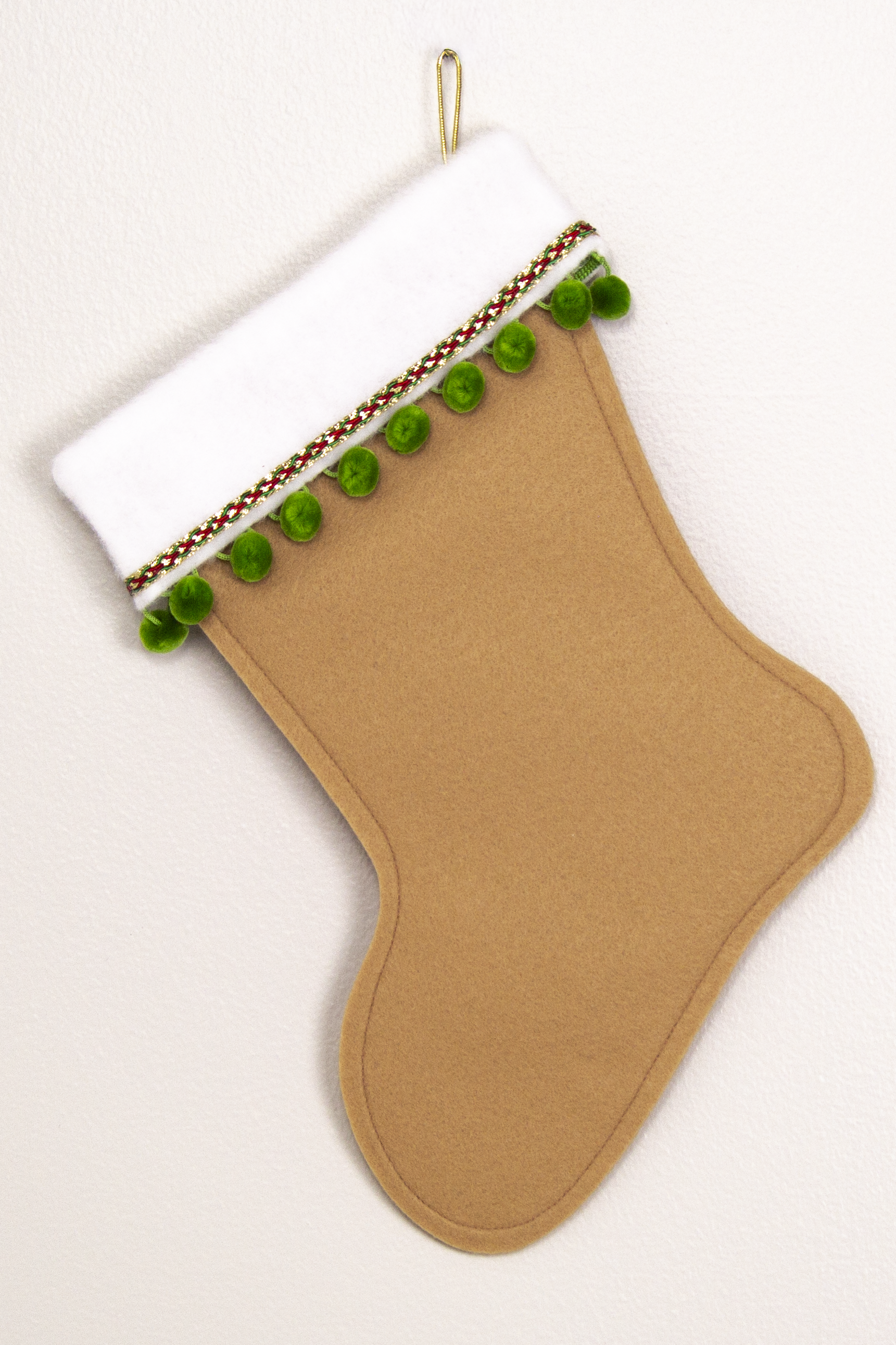 Tan felt handmade Christmas stocking with pom poms and decorated in green, red & gold. (back of Sasquatch Santa stocking)