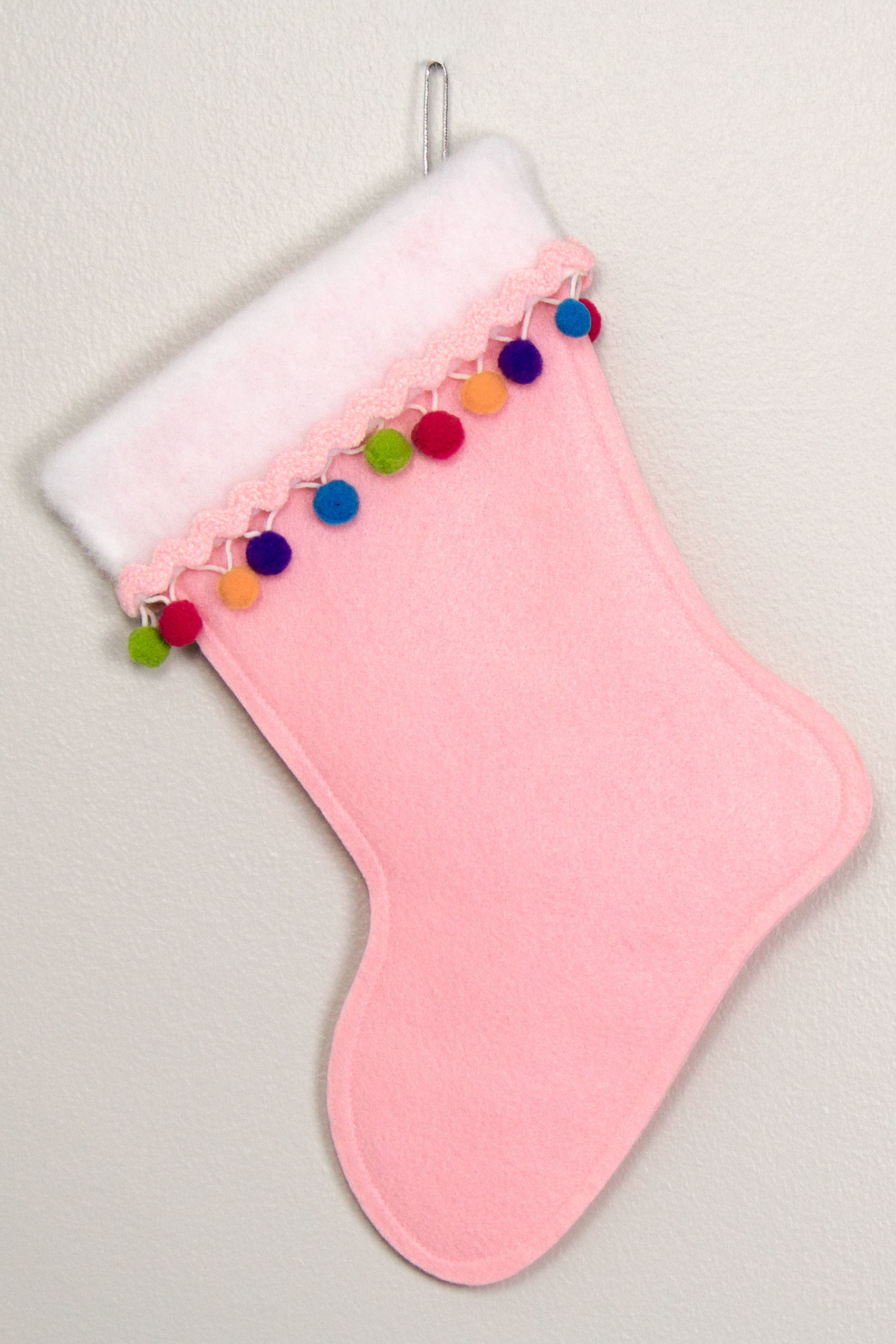 Light pink felt handmade Christmas stocking with colorful pom poms and decorated in silver & light pink. (back of Scottie dog stocking)