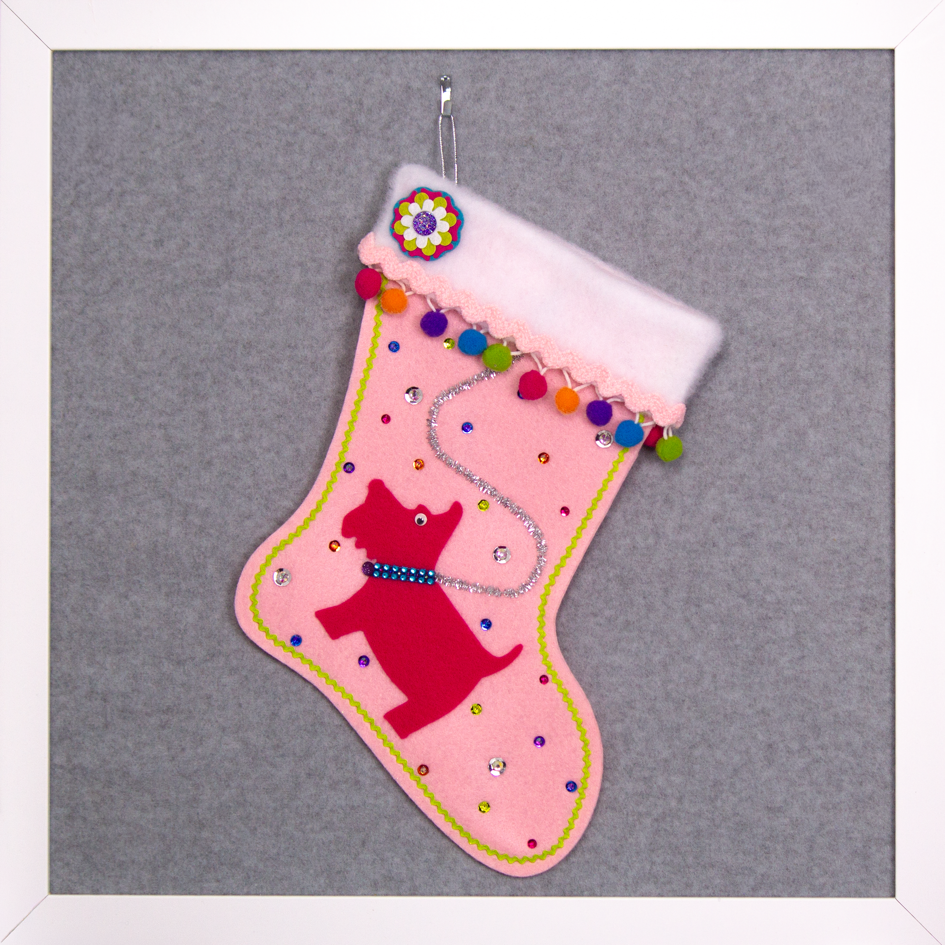 Bright pink Scottish Terrier Scottie dog on light pink felt handmade Christmas stocking with colorful pom poms and decorated in silver, pink, orange, purple, blue & green. (front of stocking)