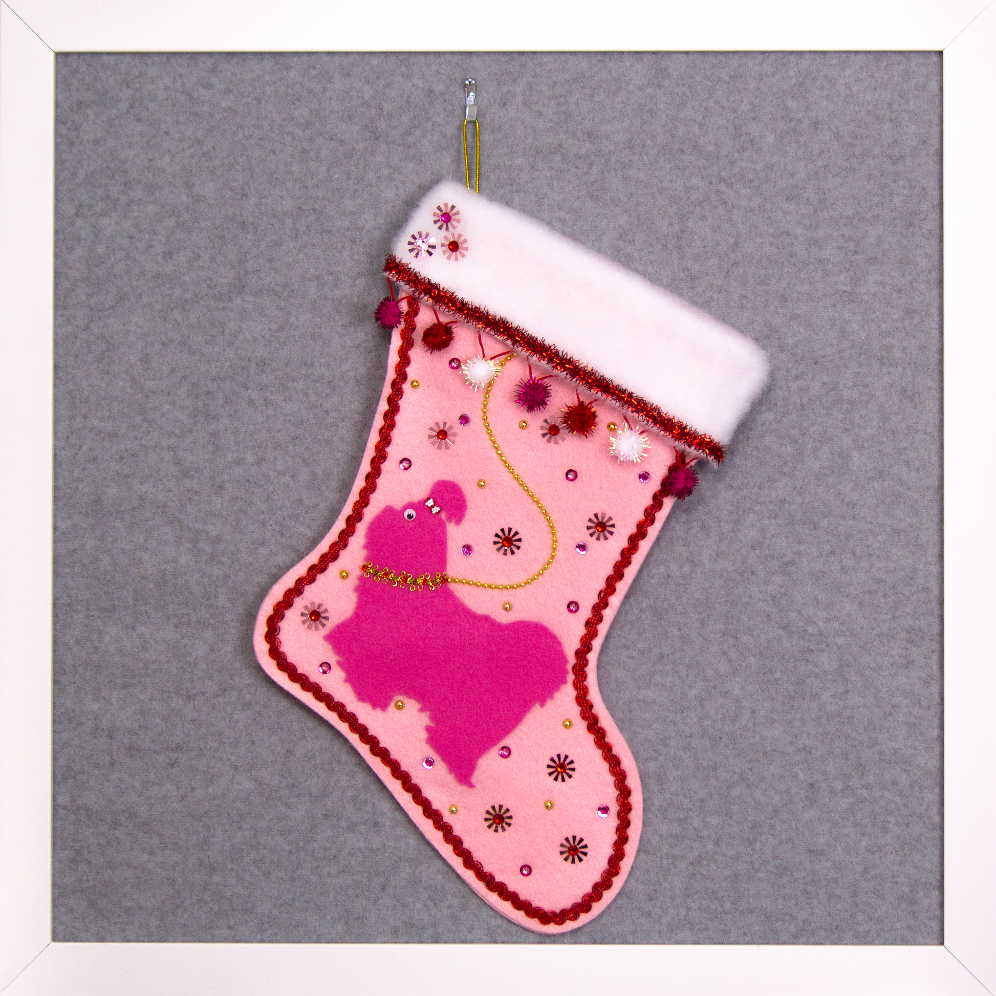 Candy pink Shih Tzu dog on light pink felt handmade Christmas stocking with sparkly pom poms, flower sequins, tinsel and decorated in red, pinks, white and gold. (front of stocking)