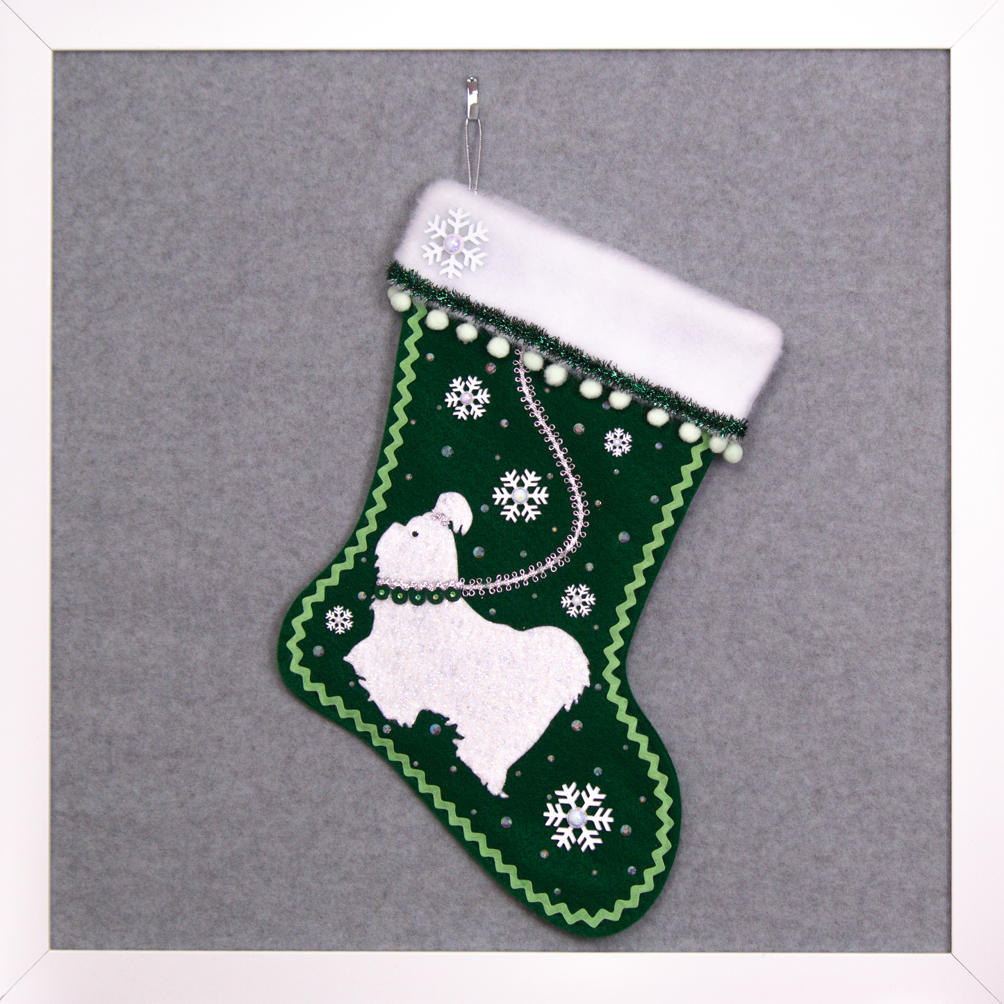Glittered white Shih Tzu dog on dark green felt handmade Christmas stocking with pom poms, snowflake buttons, tinsel ribbon and decorations in white, mint green, silver, green and clear. (front of stocking)