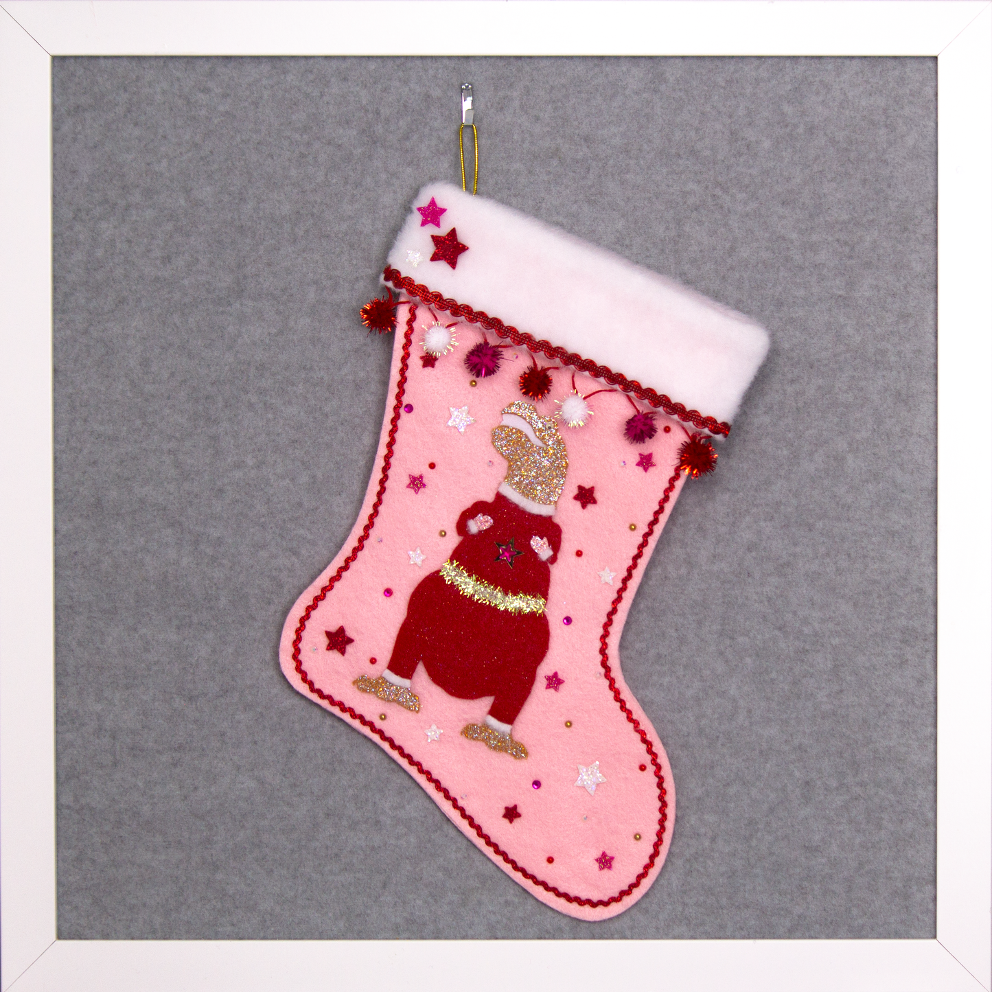 Gold glitter T-Rex with a red glitter felt suit on light pink felt handmade Christmas stocking with sparkly pom poms, felt glittery stars and decoration in red, hot pink, white & gold. (front of stocking)