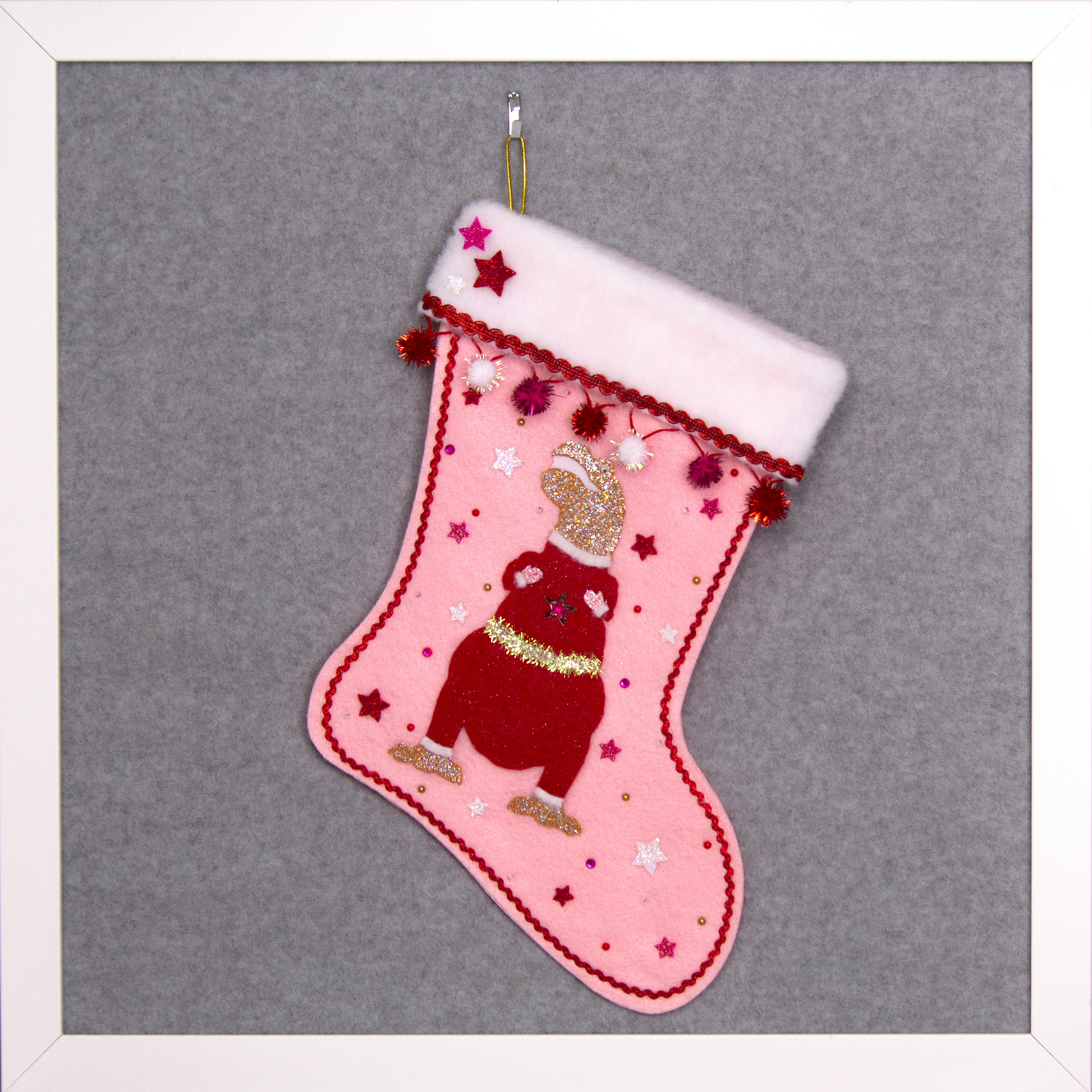 Gold glitter T-Rex with a red glitter felt suit on light pink felt handmade Christmas stocking with sparkly pom poms, felt glittery stars and decoration in red, hot pink, white & gold. (front of stocking)