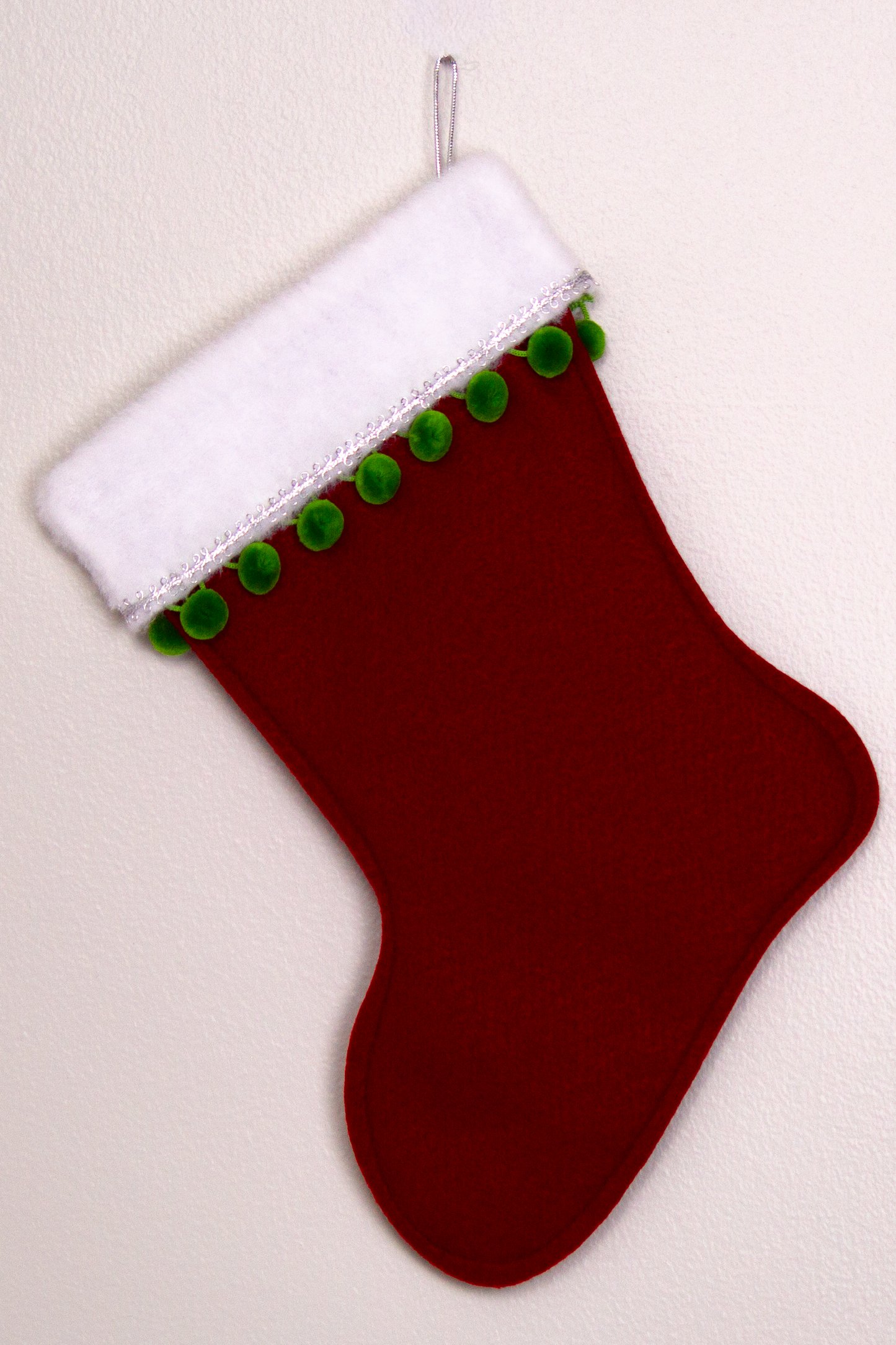 Ruby red felt handmade Christmas stocking with pom poms and decoration in green & silver. (back of T-Rex stocking)