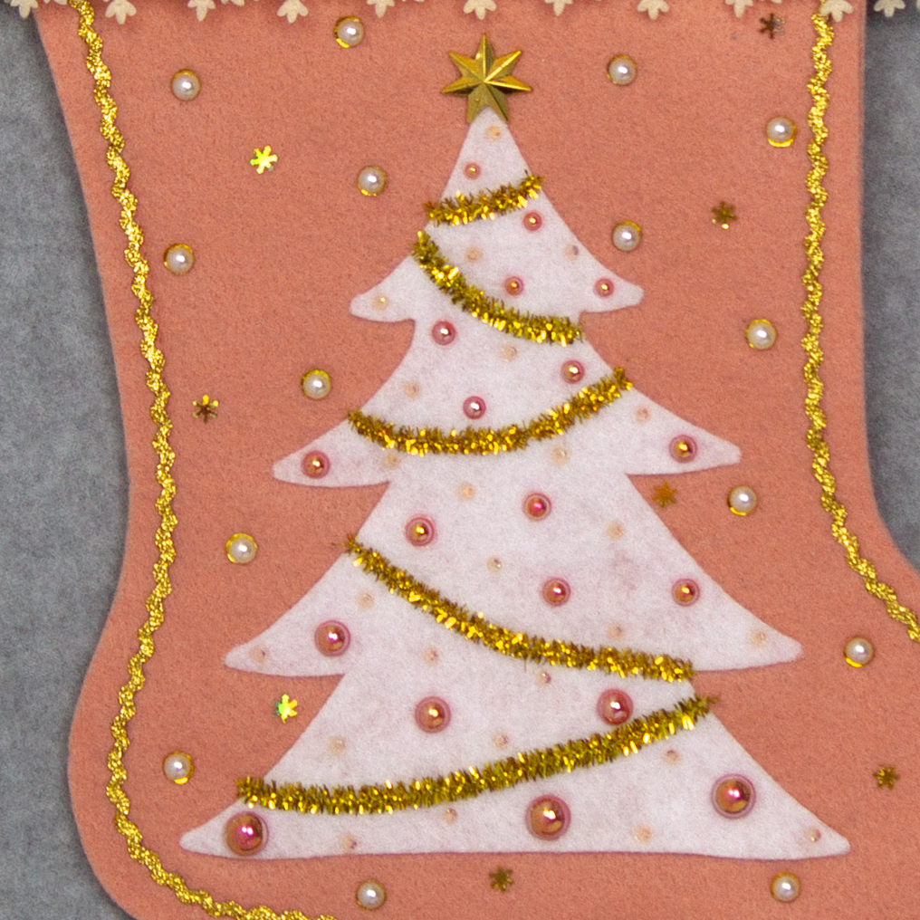White felt tree on coral felt handmade Christmas tree with delicate laser cut felt trim, plastic star buttons, tinsel pipe cleaner, tiny snowflake sequins and decorated in cream, white, coral & gold. (front of Tree stocking - close up detail of tree)