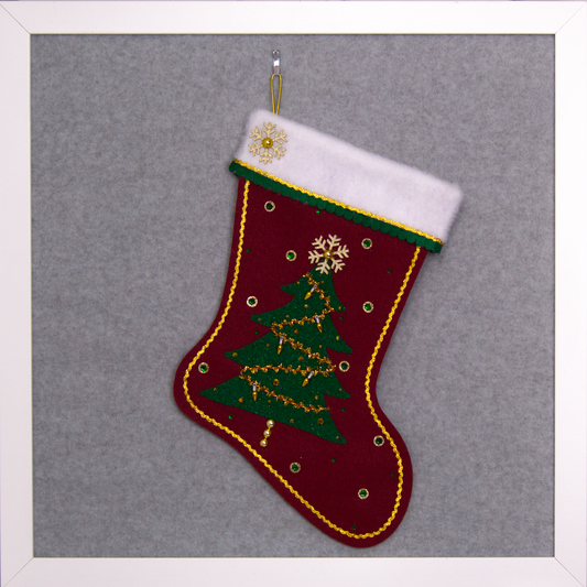Dark green glitter Christmas Tree with tinsel, fake lights and topped with a gold glitter snowflake button on a ruby red felt handmade Christmas stocking, decorated in gold, green & red. (front of stocking)