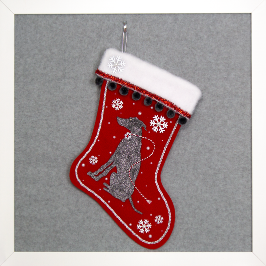 Silver glittered dark gray Whippet dog on a holiday red felt handmade Christmas stocking with snowflakes, tinsel, pom poms and decorated in red, white, dark gray and silver.