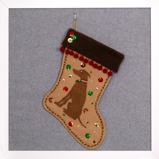Copper Whippet dog on tan felt handmade Christmas stocking with pom poms, sunburst sequins and decorated in red, green, gold and copper. (front of stocking)