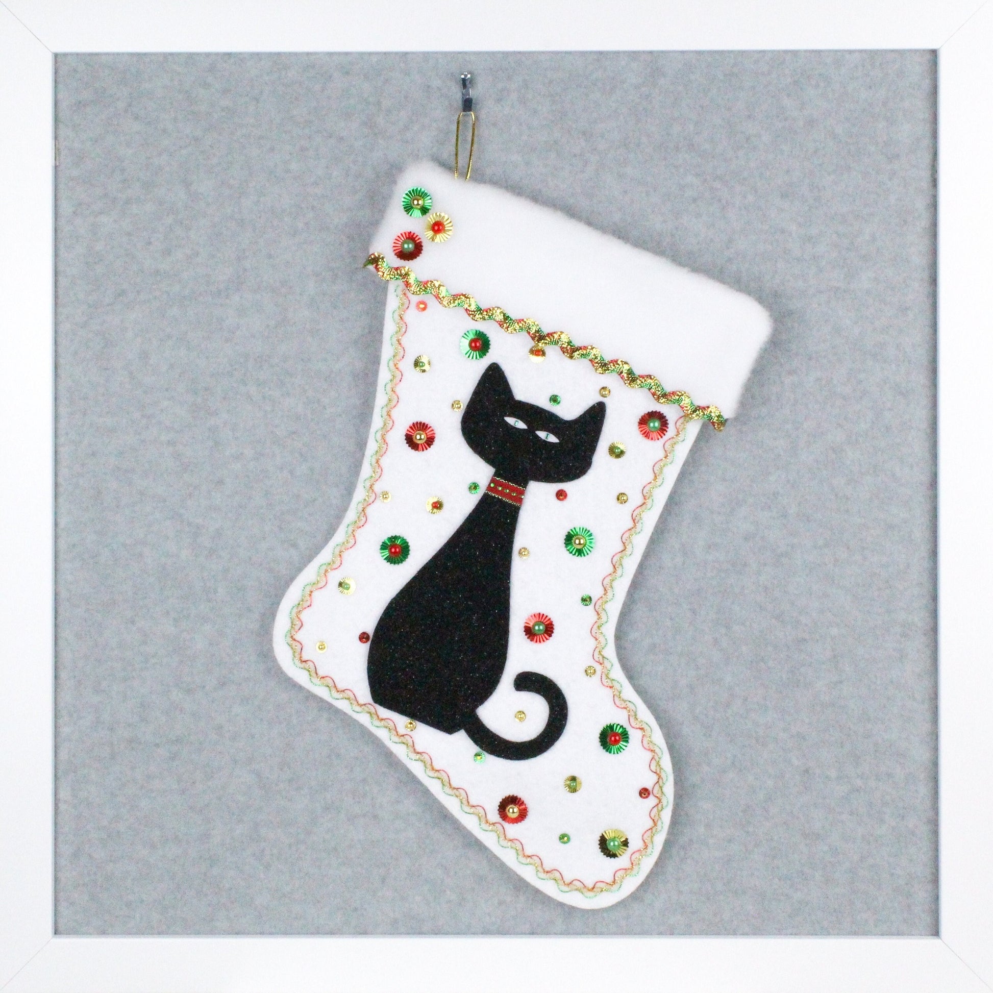 Black glitter cat on white glitter felt handmade one of a kind Christmas stocking with red, green and gold decorations.
